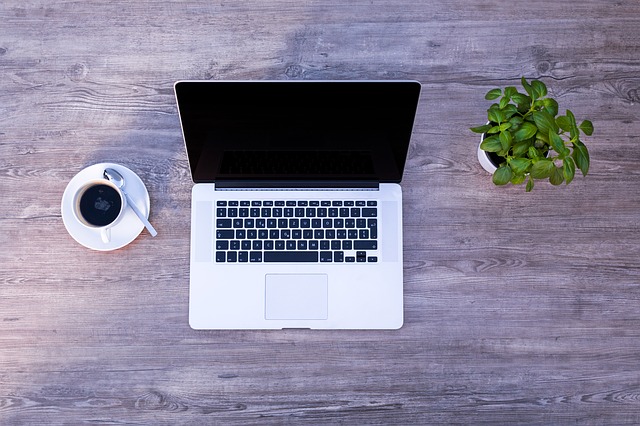 mac laptop on table nest to coffee